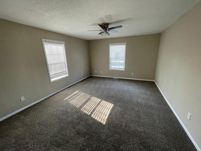 empty room featuring a ceiling fan, baseboards, a textured ceiling, and carpet flooring