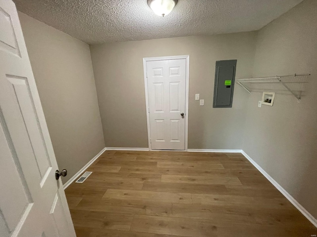 laundry area featuring hookup for a washing machine, wood finished floors, visible vents, laundry area, and electric panel