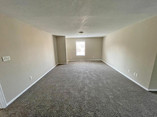 carpeted spare room with baseboards and a textured ceiling
