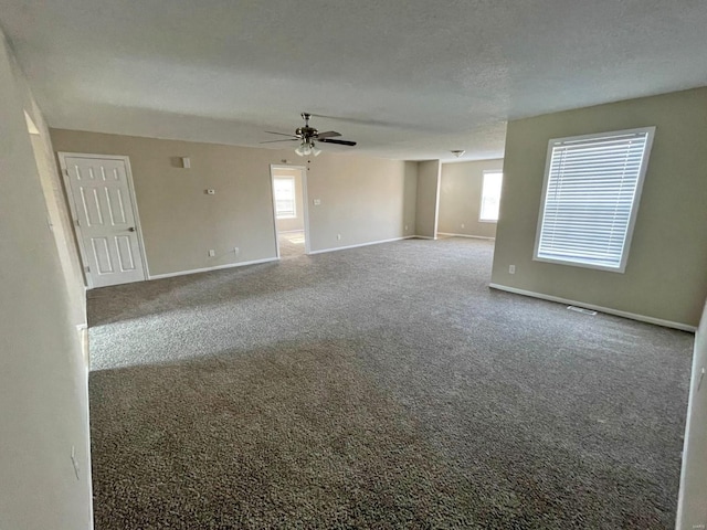carpeted empty room featuring a ceiling fan, baseboards, and a textured ceiling