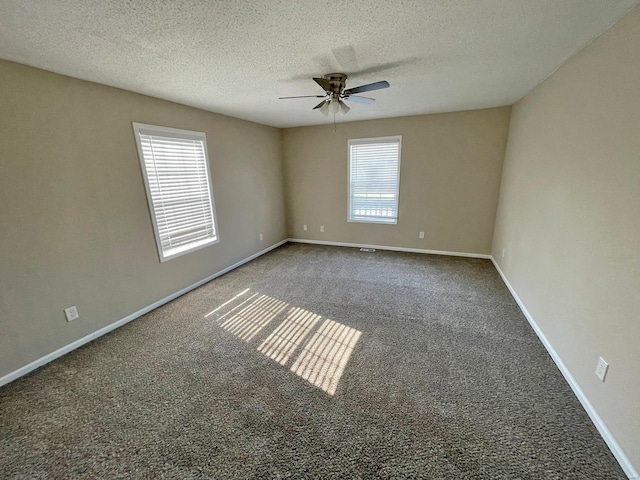 carpeted empty room with a textured ceiling, baseboards, and ceiling fan