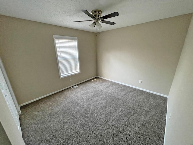 spare room featuring visible vents, baseboards, ceiling fan, and carpet flooring