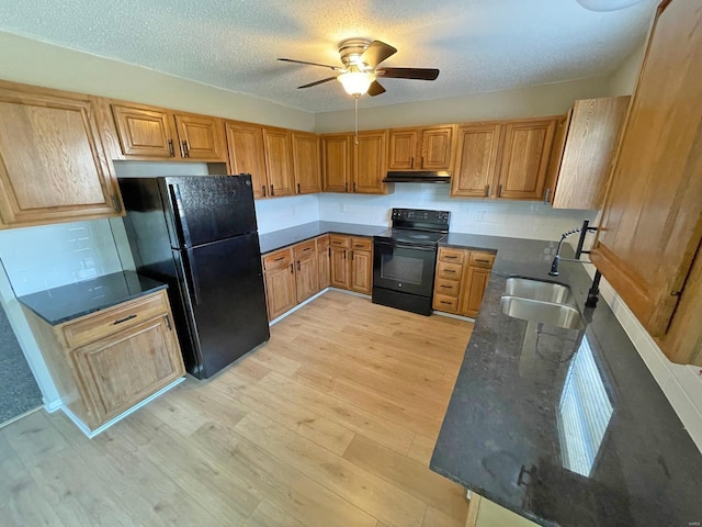 kitchen with light wood-type flooring, black appliances, under cabinet range hood, a sink, and ceiling fan