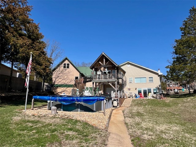 back of property with a yard, a trampoline, a fenced in pool, and a balcony