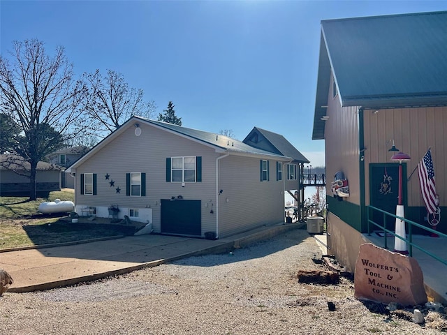 exterior space featuring central air condition unit, concrete driveway, and a garage