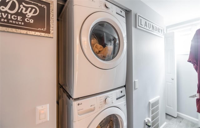 laundry room featuring visible vents, stacked washer / drying machine, and laundry area