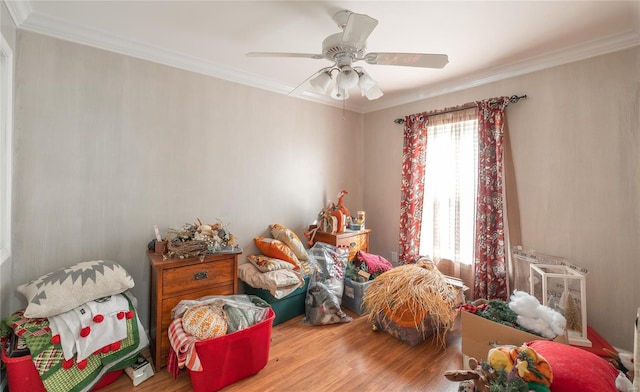 interior space featuring wood finished floors, ceiling fan, and ornamental molding