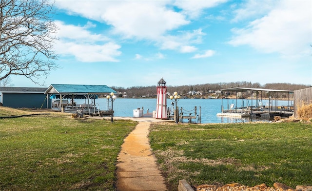 view of dock featuring boat lift, a water view, and a yard