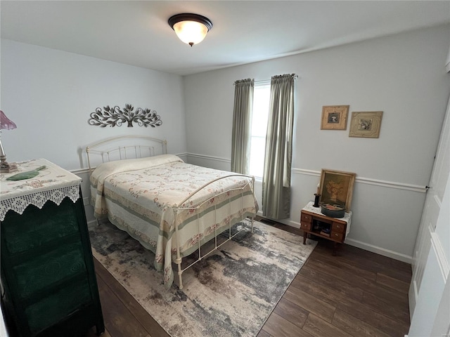 bedroom with baseboards and wood finished floors