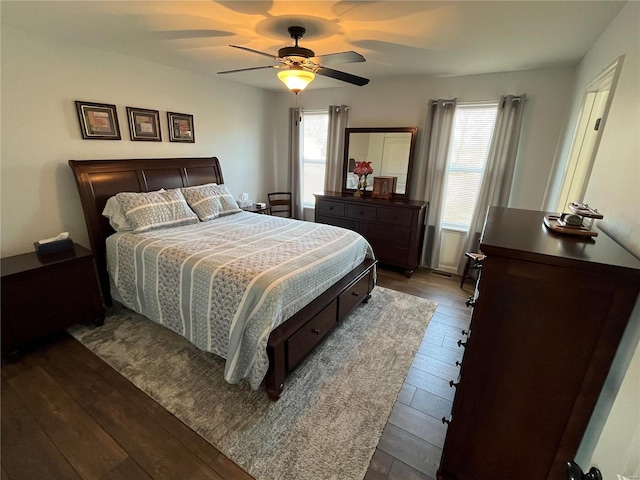 bedroom featuring multiple windows, dark wood-style flooring, and ceiling fan