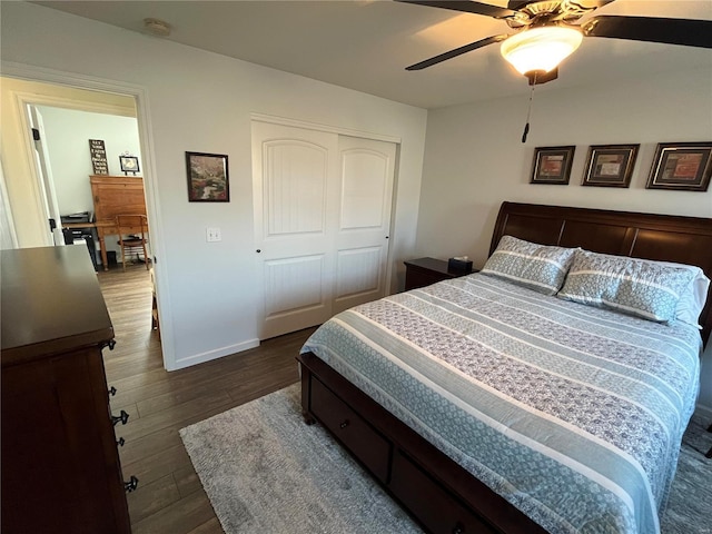 bedroom with a closet, baseboards, dark wood-type flooring, and a ceiling fan