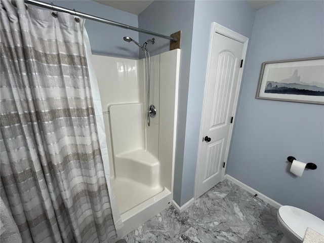 full bath featuring curtained shower, toilet, baseboards, and marble finish floor