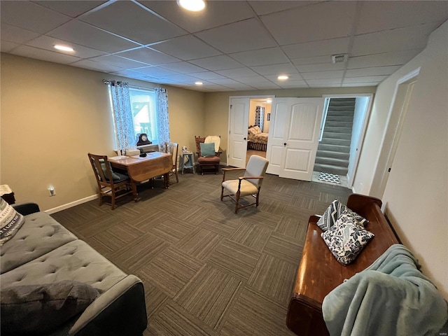 living room with a paneled ceiling, baseboards, and dark carpet