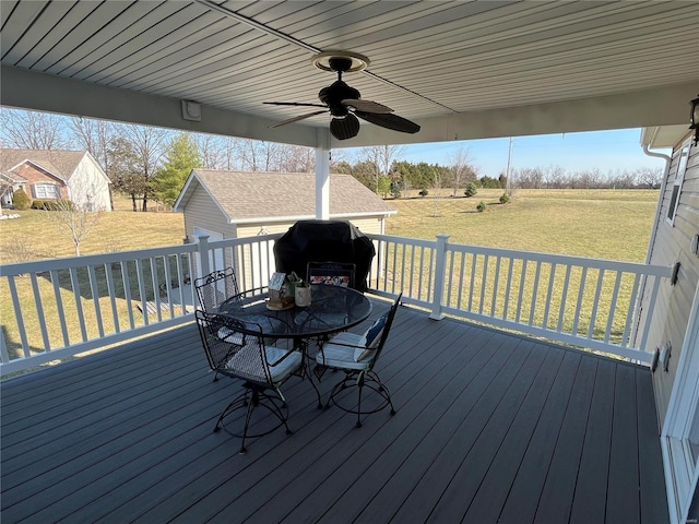 deck with a yard, area for grilling, ceiling fan, and outdoor dining space