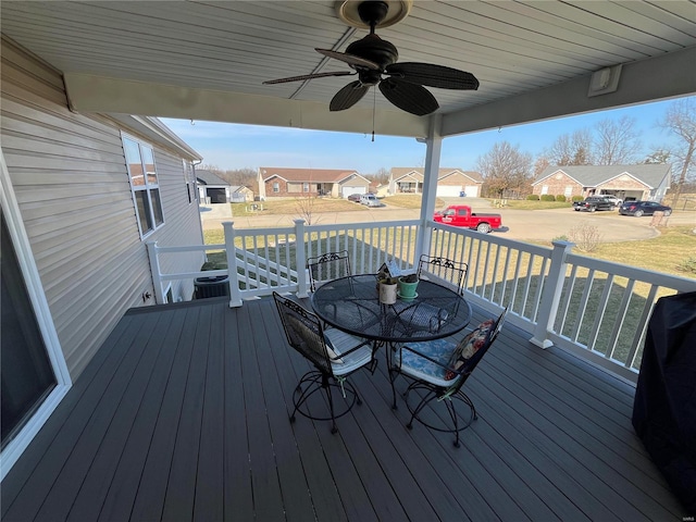 wooden terrace with grilling area, a residential view, and ceiling fan