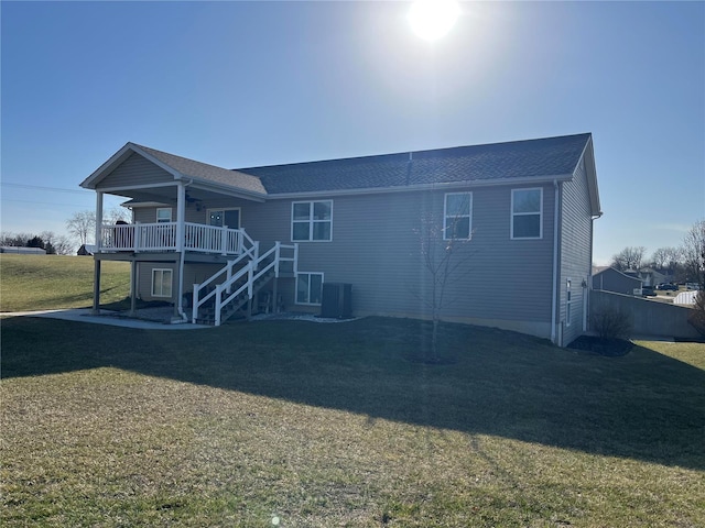 back of property featuring a lawn, a ceiling fan, stairway, cooling unit, and a wooden deck