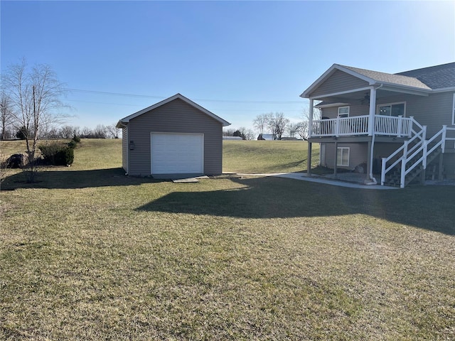 view of yard featuring stairway, ceiling fan, a detached garage, and an outdoor structure