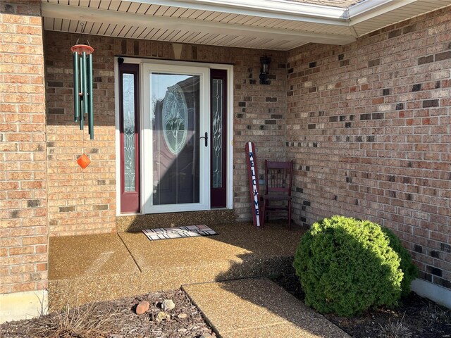 entrance to property featuring brick siding