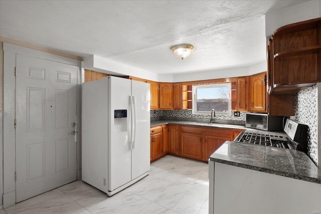 kitchen featuring open shelves, marble finish floor, and white refrigerator with ice dispenser