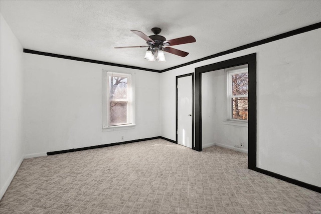 unfurnished bedroom with a textured ceiling, carpet flooring, baseboards, and ornamental molding