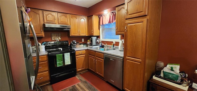 kitchen featuring a sink, light countertops, dark wood-type flooring, under cabinet range hood, and appliances with stainless steel finishes