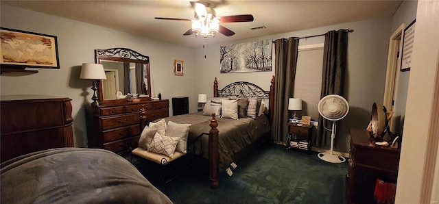 bedroom featuring dark colored carpet, visible vents, and a ceiling fan