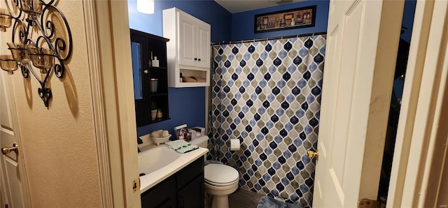 bathroom featuring a shower with shower curtain, toilet, and vanity