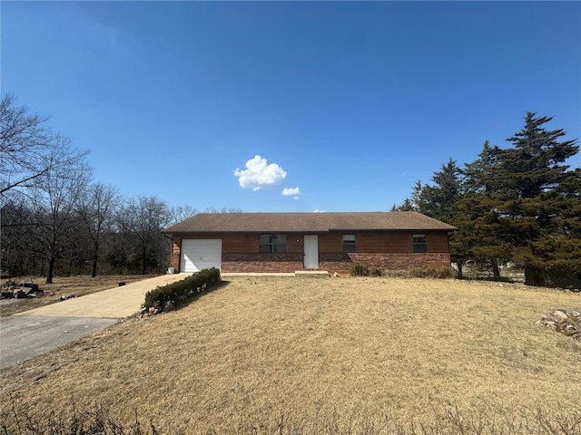 ranch-style house with a front lawn, an attached garage, and driveway