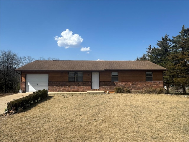 ranch-style home featuring a front yard, an attached garage, and brick siding