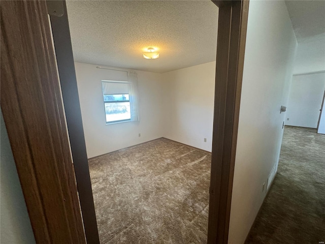 carpeted empty room with a textured ceiling