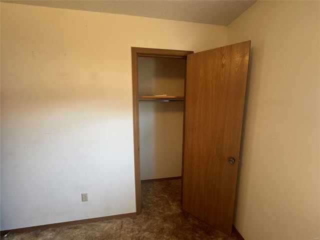 unfurnished bedroom featuring a closet, carpet floors, and baseboards