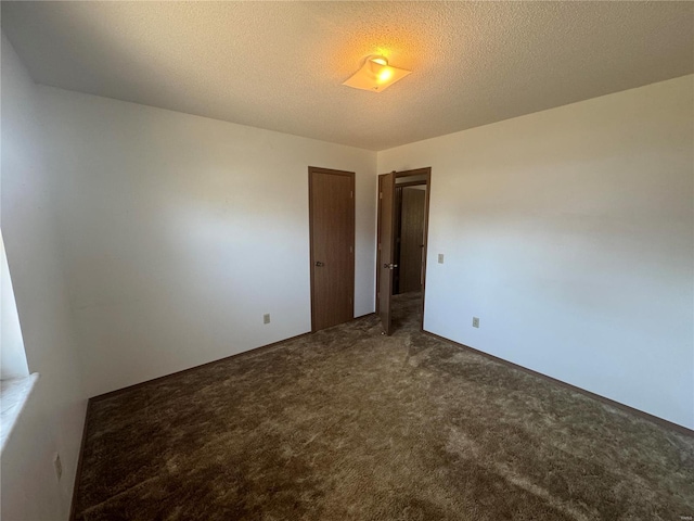 carpeted empty room with a textured ceiling