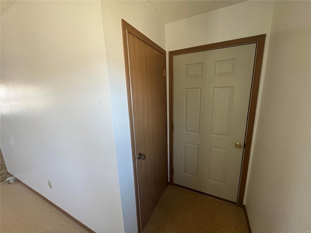 hallway featuring baseboards and a textured ceiling