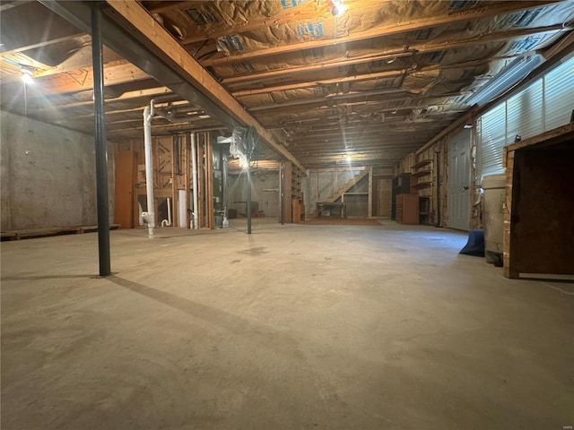 unfinished basement featuring stairs