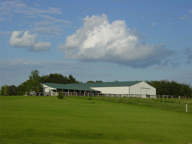 view of property's community featuring a rural view, an outbuilding, and fence