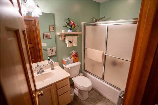 full bathroom featuring bath / shower combo with glass door, toilet, and vanity