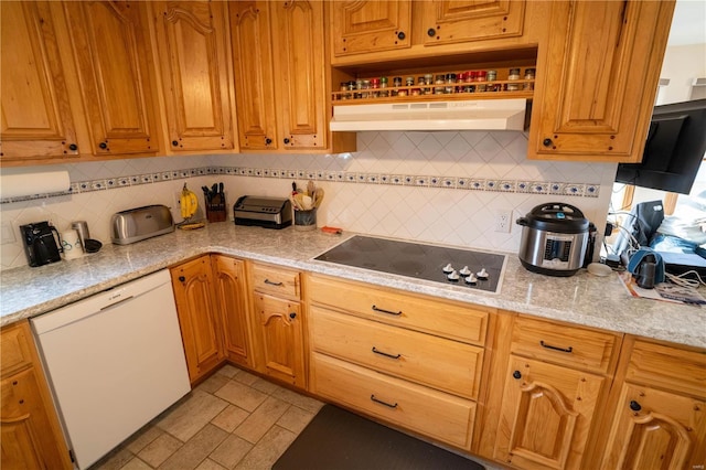 kitchen with white dishwasher, brown cabinetry, decorative backsplash, black electric stovetop, and under cabinet range hood