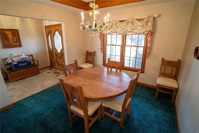 carpeted dining area featuring baseboards and a chandelier