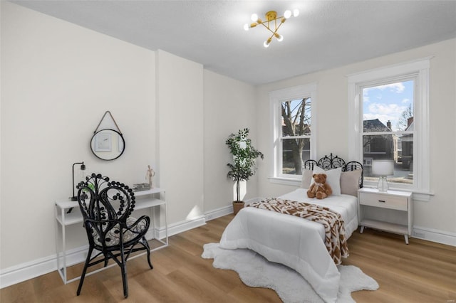 bedroom featuring baseboards and wood finished floors