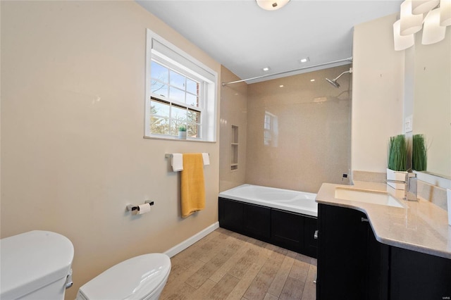 full bathroom featuring vanity, wood finished floors, baseboards, shower / washtub combination, and toilet