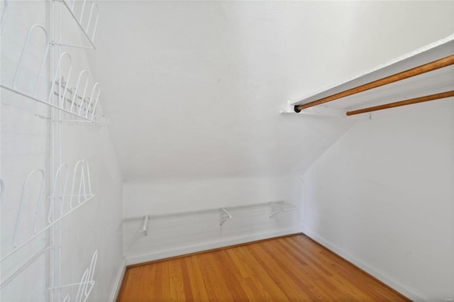 walk in closet with lofted ceiling and light wood-type flooring