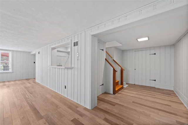 below grade area featuring visible vents, stairs, and hardwood / wood-style flooring