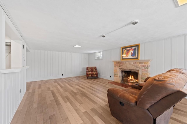 living room featuring light wood finished floors and a brick fireplace