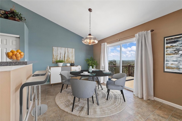 dining room featuring baseboards and vaulted ceiling