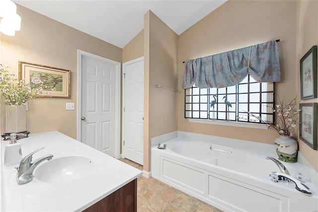 bathroom with vanity, lofted ceiling, a bath, and tile patterned floors