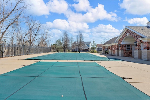 pool with a patio and fence