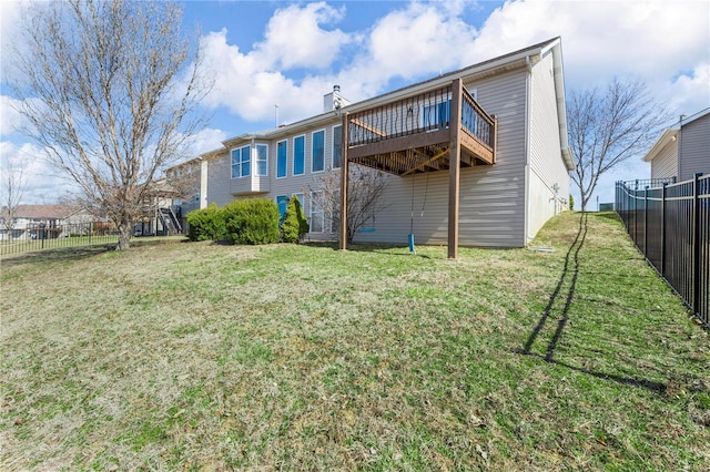 back of property with a wooden deck, fence, a lawn, and a chimney