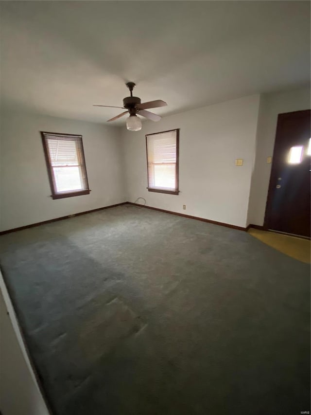 carpeted empty room with baseboards and ceiling fan