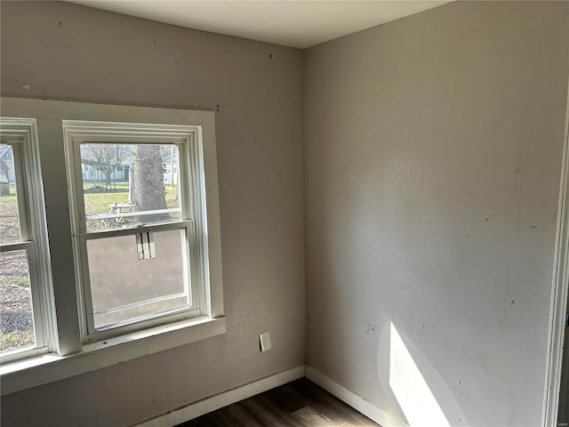 unfurnished room with dark wood-type flooring and baseboards