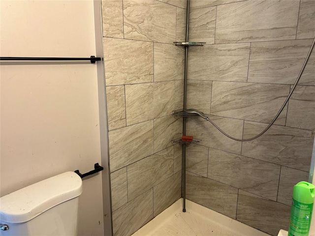 full bath featuring toilet and a tile shower